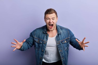 frustrated man with wide opened mouth screaming with great fear and anger.