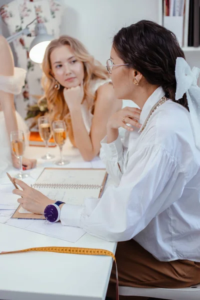 Apuesto diseñador sastre de vestidos de novia y mujeres jóvenes — Foto de Stock