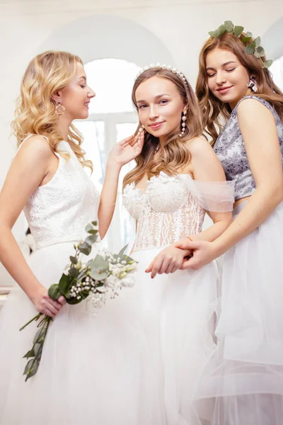 Három kaukázusi barátnő próbálja fel esküvői ruhák — Stock Fotó