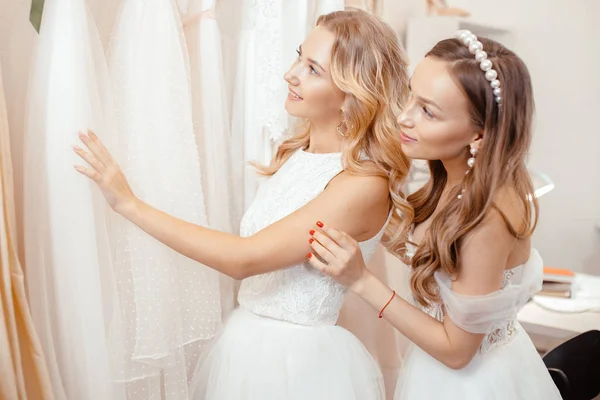 Young caucasian girlfriends dream about and choosing wedding dress — 스톡 사진