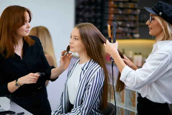Estilista na moda fazendo maquiagem para jovem caucasiano feminino — Fotografia de Stock