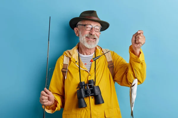 Smiling cheerful old fishman boasting about his catch — 스톡 사진