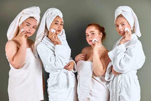 Портрет красивых молодых женщин в полотенцах и халате с использованием ваты — стоковое фото