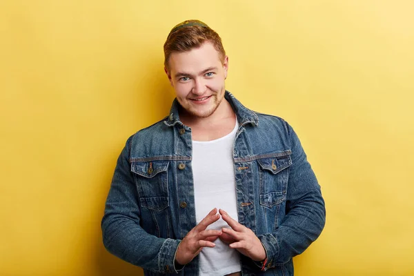 Handsome man keeping finger to finger with serious expression looking at camera — Stock Photo, Image