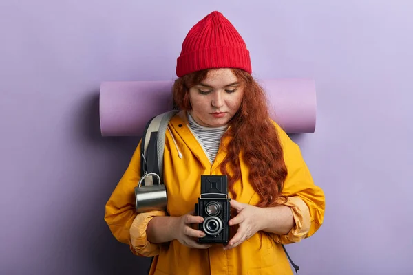 Giovane attraente turista donna con fotocamera e zaino, isolato su blu — Foto Stock