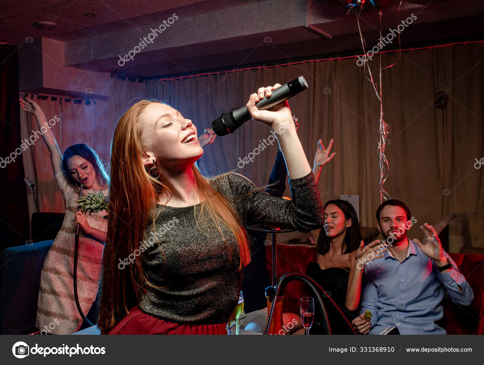 Рыжая Молодая Женщина Поет В Караоке-Баре Стоковое Фото.