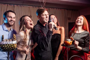 group of young people rocking in karaoke bar clipart