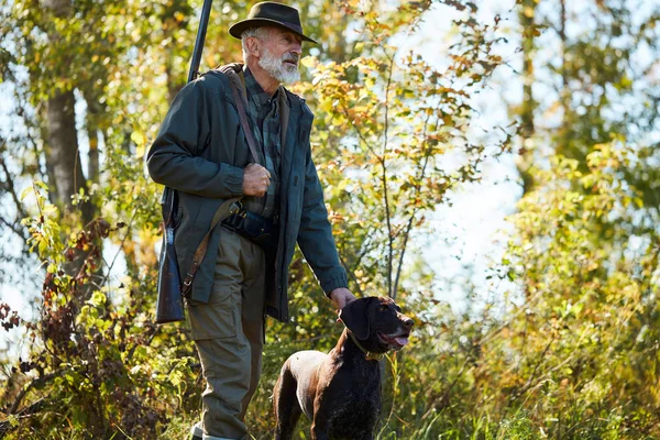 Caçador com rifle e labrador na floresta — Fotografia de Stock