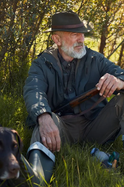 Potěšený lovec muž sedí se psem — Stock fotografie