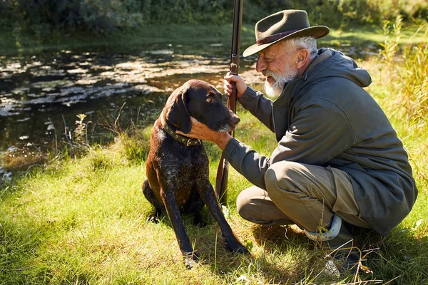 Hunter e seu cão fazem uma pausa na floresta — Fotografia de Stock