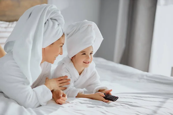 Beautiful caucasian mother and daughter going to watch tv — Stock Photo, Image