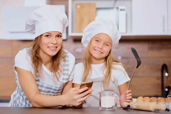 Portret pięknej kobiety i jej dziecka w kuchni, gotowania i koncepcji piekarni — Zdjęcie stockowe