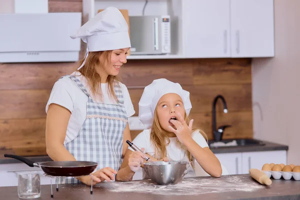 Matka i dziecko degustacja mąki w kuchni — Zdjęcie stockowe