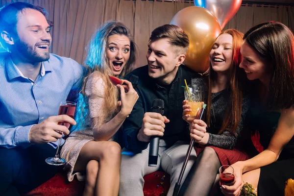 joyful happy young people have party in karaoke bar