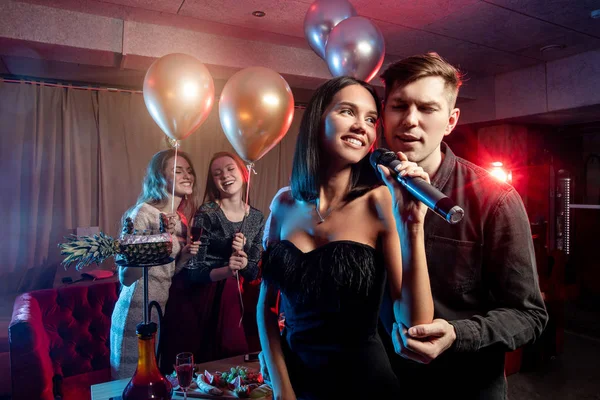 Chicos jóvenes y damas tienen tiempo de fiesta en el karaoke — Foto de Stock