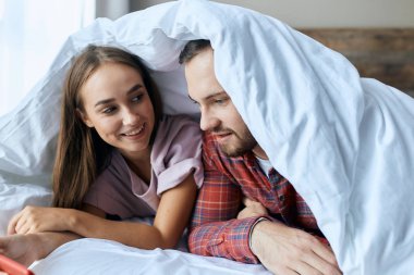 Mutlu çift beyaz battaniyenin altında