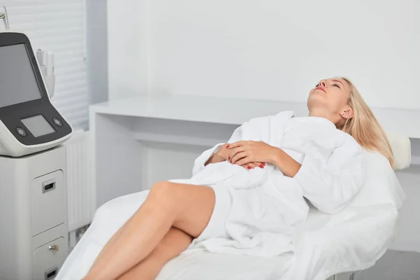 Vacker avslappnad kvinna i badrock liggande och väntar ansiktsvård förfarande — Stockfoto