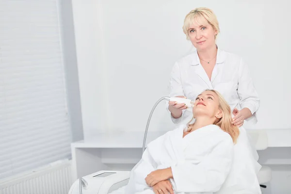 Cosmetologo esperto di talento migliorare il volto del cliente bionda femminile — Foto Stock