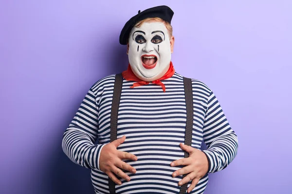 Szalony clown w paski sweter, suspendersm beret zabawy w studio — Zdjęcie stockowe