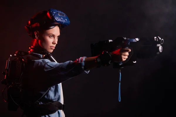 Donna seria con pistola per gioco virtuale pronto a sparare — Foto Stock