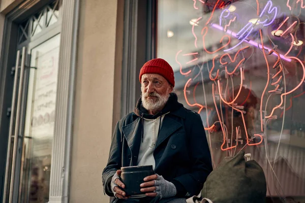 Lástima hombre mayor sentado en la calle y pedir dinero —  Fotos de Stock