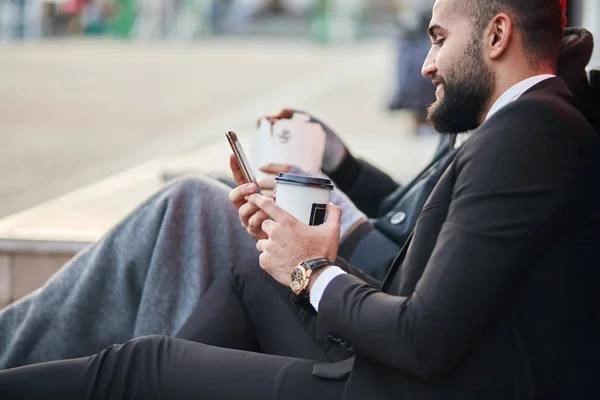 Vista laterale su uomo d'affari in possesso di caffè e telefono — Foto Stock