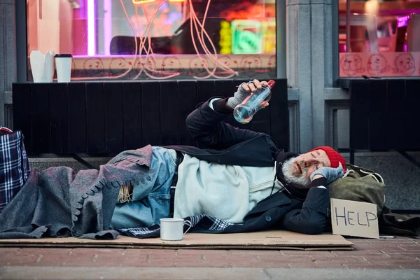Hombre sin hogar acostado en una caja de cartón — Foto de Stock
