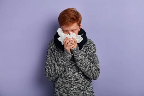 Hombre sosteniendo una pila de servilletas, sonándose la nariz. estudiante tiene mirada enferma —  Fotos de Stock