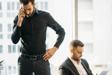 Genç iş adamı telefonda konuşuyor.