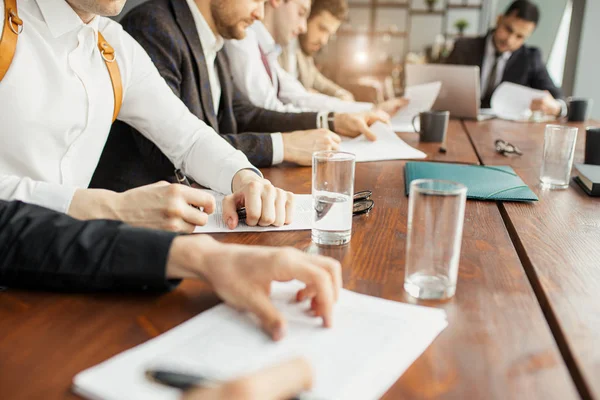 Cropped business people sitting on table in office — 스톡 사진