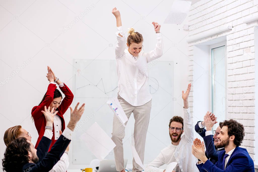 young caucasian business woman dance on table in office