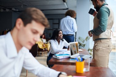 Modern ofiste takım çalışması. Yeni başlayan projeyle çalışan genç işletme müdürünün fotoğrafı.