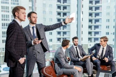 Smokinli yakışıklı adamlar iş birliği yapıyor.