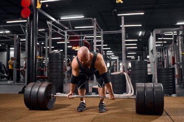 Spor salonunda halterli sporcu.