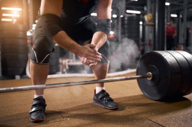 Atlet kaldırmadan önce el çırpıyor