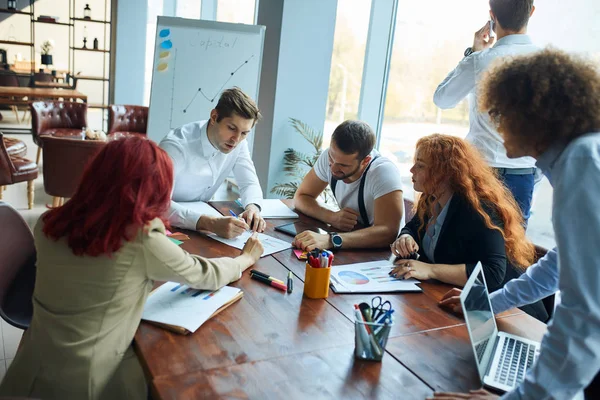 Teamwork-Prozess eines jungen Teams kaukasischer Mitarbeiter, die große geschäftliche Diskussionen im modernen Büro führen — Stockfoto