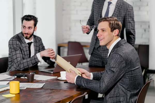 Öltönyös fiatal férfiak üzleti megbeszélésen — Stock Fotó