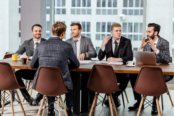Young men in suits gathered in business meeting — Stock Photo, Image