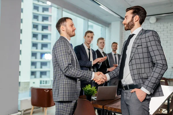 young business partners shaking hands
