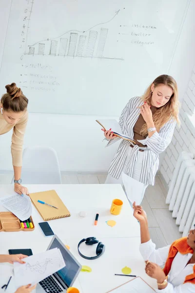 Brainstorm de jovens senhoras de negócios co-trabalhando em escritório moderno branco — Fotografia de Stock