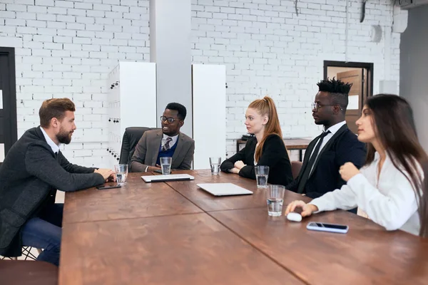Международная группа деловых людей сидит вместе за столом — стоковое фото