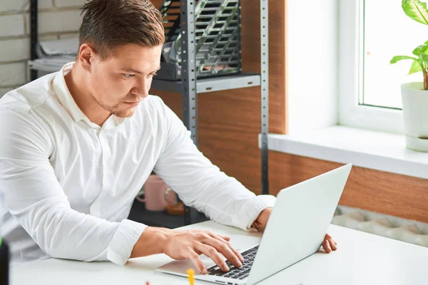 Jonge zakenman op zoek naar laptop computerscherm tijdens het werken in het kantoor — Stockfoto