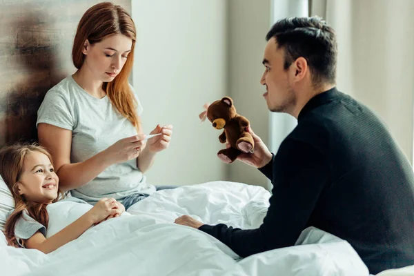 Portrait of lovely family on bed at home — Stock Photo, Image