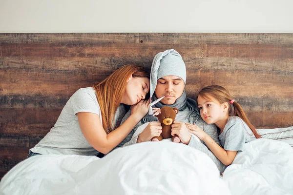 Caucasian family together on bed, funny ill father — ストック写真