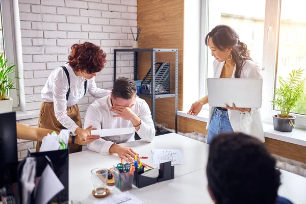 Tired exhausted man surrounded by co-workers — Stock Image Tired exhausted man surrounded by co-workers Royalty Free Stock Images