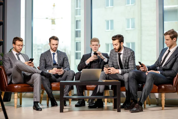 Jóvenes empresarios con teléfonos móviles —  Fotos de Stock