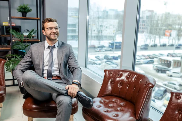 Молодий бізнесмен у костюмі сидить в офісі — стокове фото