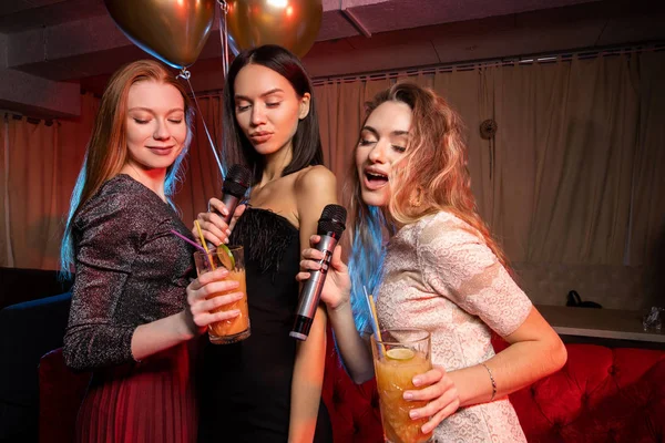 Fröhliche Freunde Mädchen und Jungen singen gemeinsam Karaoke in Bar — Stockfoto