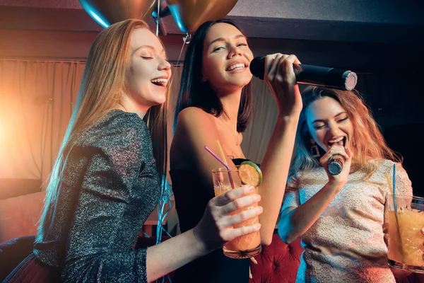 Alegres amigos felices divertirse y cantar en la fiesta de karaoke en el club nocturno —  Fotos de Stock