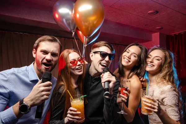 Grupo de jóvenes tienen fiesta, vacaciones, relax y celebración en el karaoke — Foto de Stock